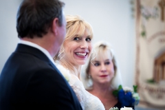 ride smiles at her groom during the wedding ceremony at the altar.