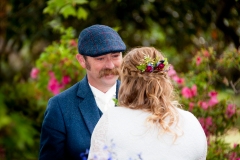 Groom gazes lovingly at his bride, smiling, with spring azaleas in full bloom at Wiseacre Estate in Norfolk, VA.