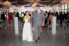 Bride and groom walk down the aisle, holding hands and smiling after their wedding ceremony.