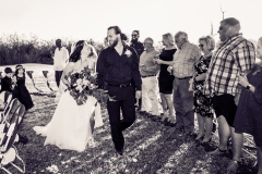 Bride and groom walk hand in hand down a unique spiral wedding aisle in Elizabeth City, NC, surrounded by close family and friends.